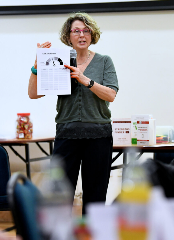 Dr Jan holding up a paper whilst leading a workshop on equality and inclusion in STEM