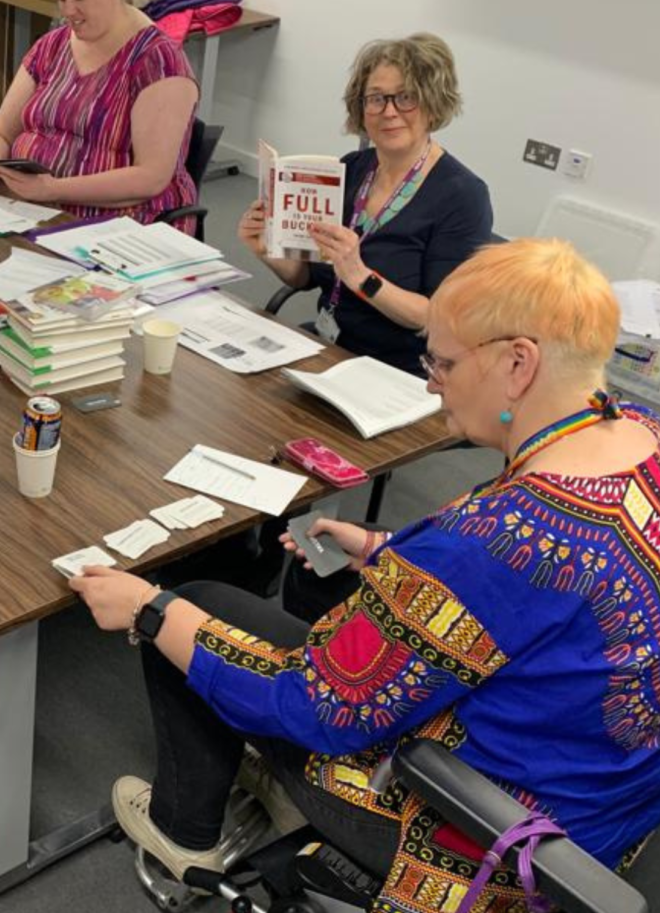 Dr Jan and others sitting around a table and working collaboratively